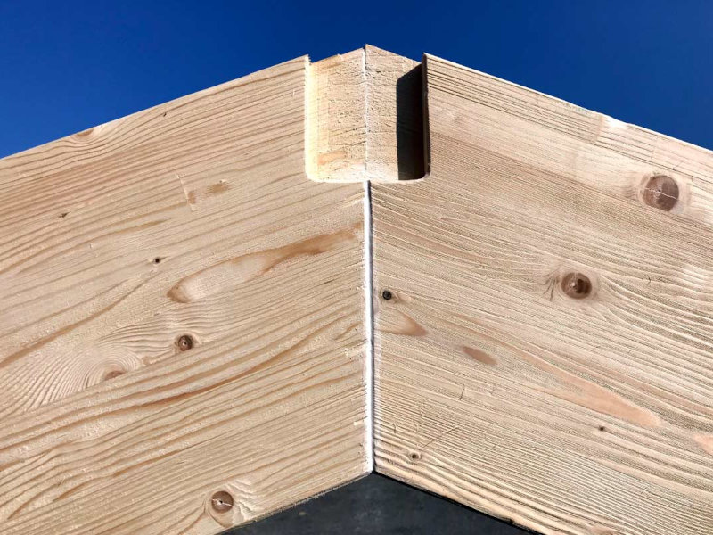 Dettaglio dell'incastro tra due travi in legno con giunzione strutturale a vista
