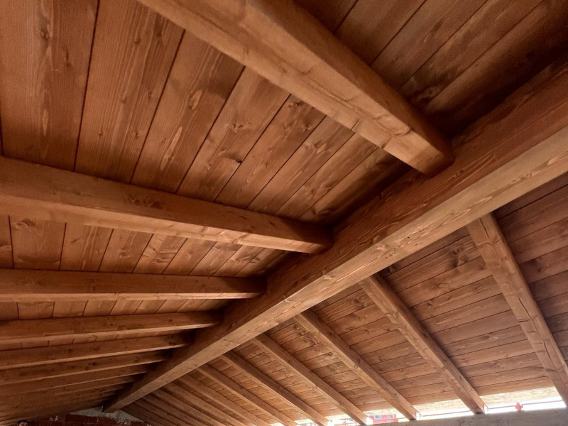 Interno con tetto in legno a travi a vista durante la realizzazione