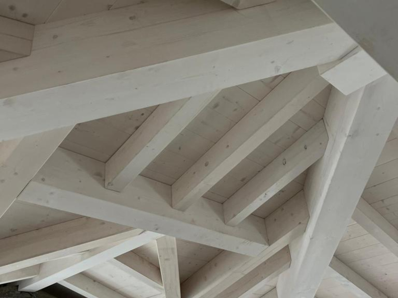 Interno con tetto in legno a travi bianche a vista